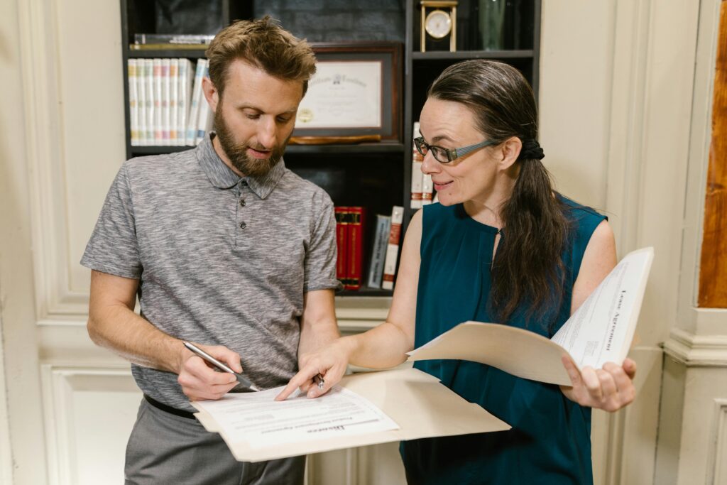 An Australian immigration lawyer showing a client where to sign a visa application