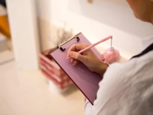 A doctor writing the Australia visa health requirements on a clipboard