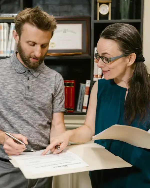 An Australian immigration lawyer showing a client where to sign a visa application